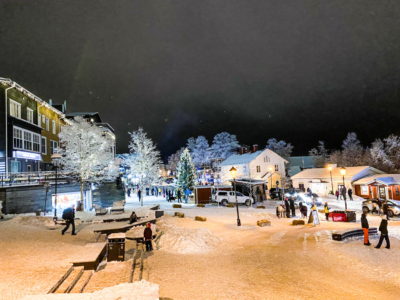 Snöigt torg i Åre by med julbelysning på kvällen