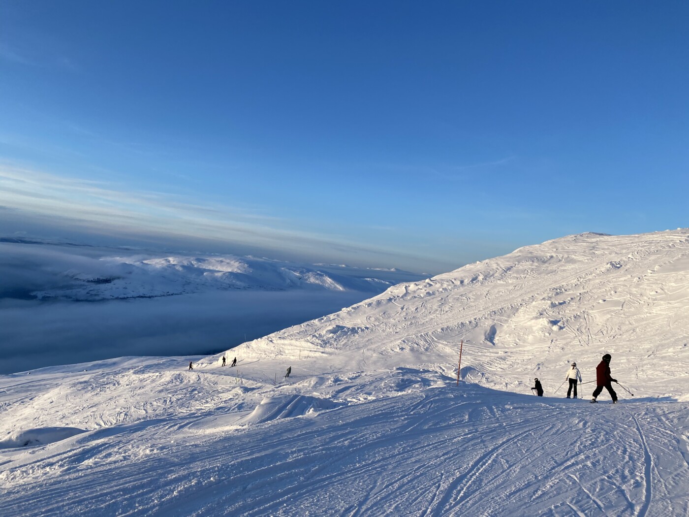 Skidåkare på soligt kalfjäll under blå himmel i Åre